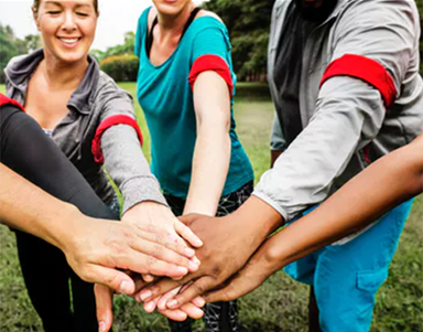 People in a group putting hands together